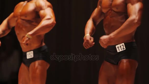 Bodybuilding tävling deltagarna visar rippade muskler i avslappnad pose — Stockvideo