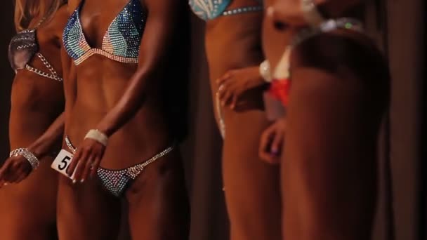 魅力的な女性のフィットネス ビキニ コンテストで完璧なフラット腹を示す — ストック動画