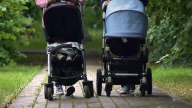 Anneler, bebekler bebek arabası ile Park'ta yürüyordunuz Annelik ödemek, ebeveynlik