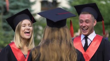 Öğrenciler akademik elbiseli sarılma arkadaşlar mezun yüzündeki mutluluk