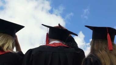 Üniversite atma akademik Kapaklar yukarı geleceğe bakıyor mavi gökyüzünde mezunu