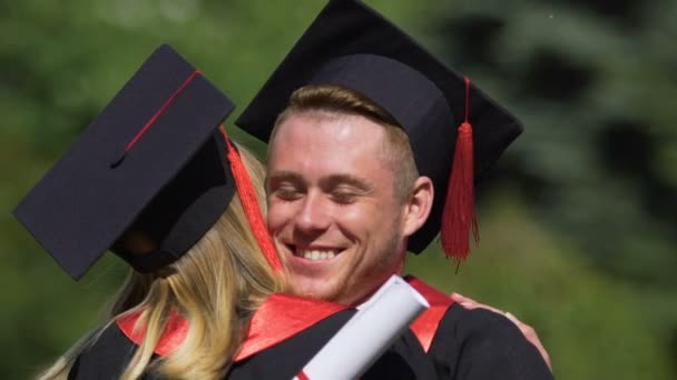 Estudiantes graduados exitosos abrazando y riendo alegremente, amistad — Vídeos de Stock