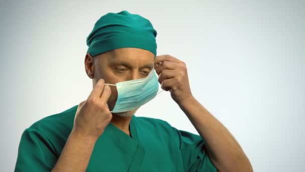 Mannelijke arts gezichtsmasker zetten te onderzoeken patiënt, bescherming tegen ziekte — Stockvideo