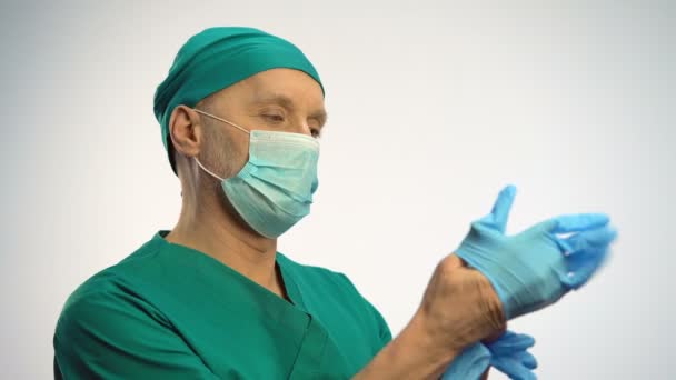 Médecin portant un masque facial portant des gants médicaux, se préparant aux procédures — Video