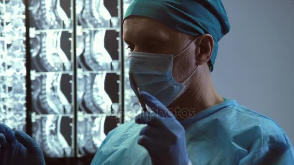 Сфокусированный хирург со скальпелем в руке кивает, чтобы начать операцию по спасению жизни — стоковое видео
