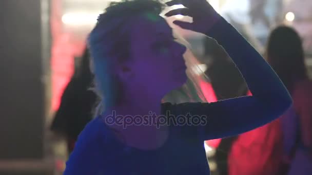 Счастливая красивая женщина двигает телом под музыку на танцевальной вечеринке с улыбкой на лице — стоковое видео