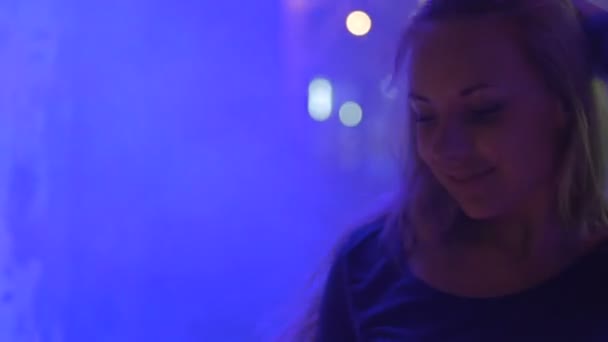 Усміхнене обличчя красивої танцівниці Go-go, що переїжджає до музики в клубі, диму та вогнів — стокове відео