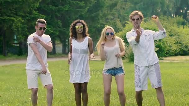 Jovens bonitos felizes em óculos de sol dançando com sorrisos em rostos, slow-mo — Vídeo de Stock