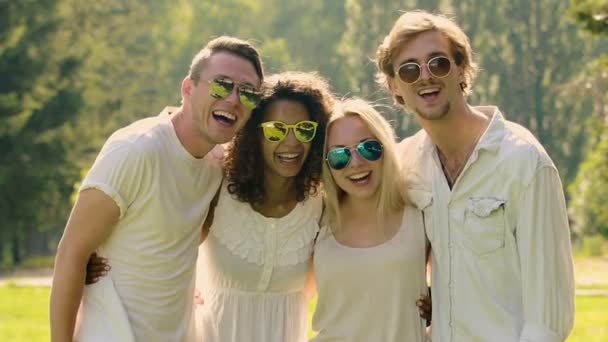 Amici maschi e femmine che si abbracciano e ridono alla macchina fotografica, godendo della vita felice — Video Stock