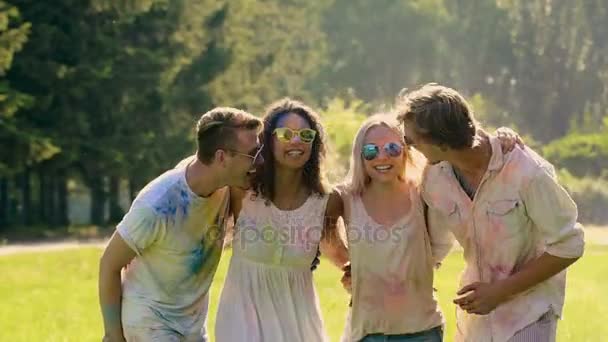 Quattro amici felici che saltano coperti di polvere colorata, tradizionale festa holi — Video Stock