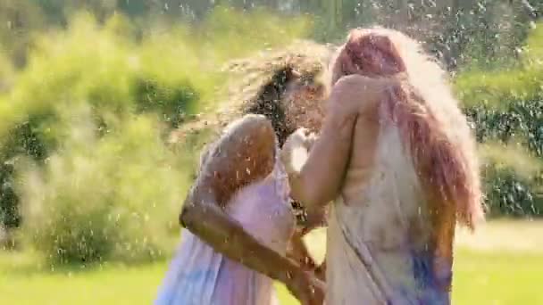 Красивые молодые женщины обнимаются и улыбаются, вода брызгает на счастливых дам — стоковое видео