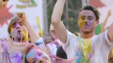 Renk Festivali'nde eğleniyor dans ve kamera için seyir aktif genç insanlar