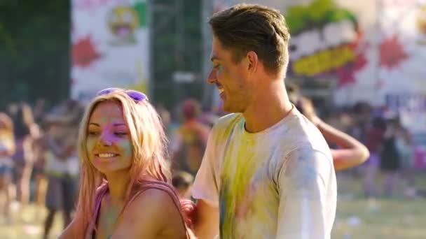 Mujer coqueta bailando con un hombre guapo sonriente en el festival de color holi, lento-mo — Vídeos de Stock