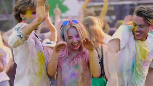 Podekscytowany młodych przyjaciół razem tańczyć festiwalu farby, ciesząc się plenerowa — Wideo stockowe