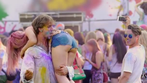 Crazy drunk man holding female friend on shoulder, slapping girls buttocks — Stock Video