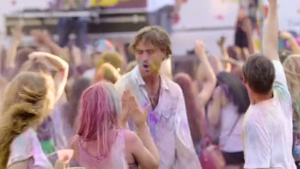 Dziki tłum chodzenie zwariowany fajne Festival, przyjaciele pokryte farbą biorąc selfie — Wideo stockowe