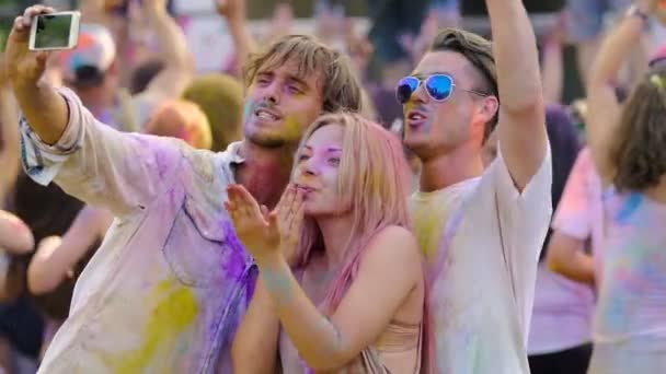 Amigos felices bailando, filmando vídeo en smartphone, festival holi, cámara lenta — Vídeo de stock