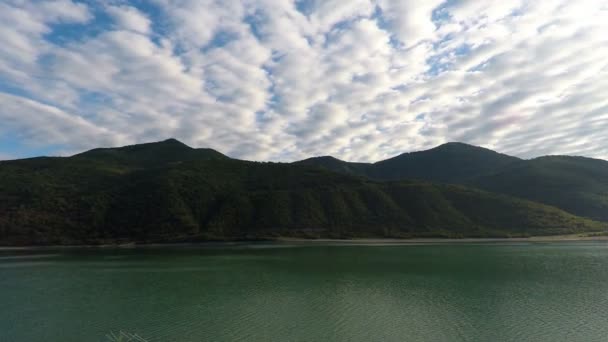 Гірські пейзажі, що зображують річку під блакитним небом з розсіяними білими хмарами — стокове відео