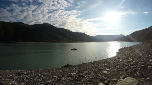 小船上划船河边的群山环绕，阳光反射在水中人 — 图库视频影像