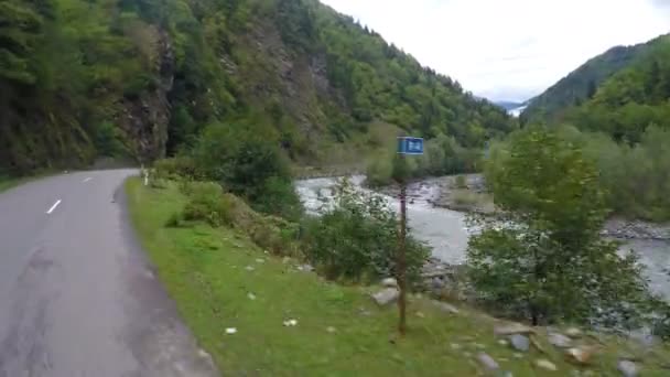 Monter sur une route de montagne sinueuse le long d'une rivière à flux rapide et des falaises escarpées — Video