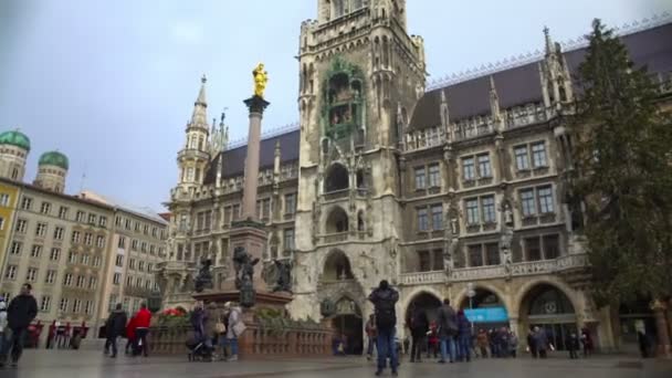 München, Németország - körülbelül 2016. január: Turisták egy városnéző túra. Turisták számára a gyaloglás, és élvezi csodálatos építészeti St. Mary téren Münchenben — Stock videók