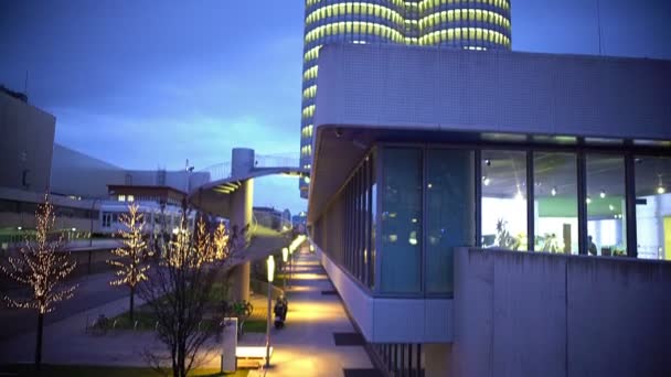 Vista del edificio iluminado alto del negocio, arquitectura moderna, árboles decorados — Vídeos de Stock