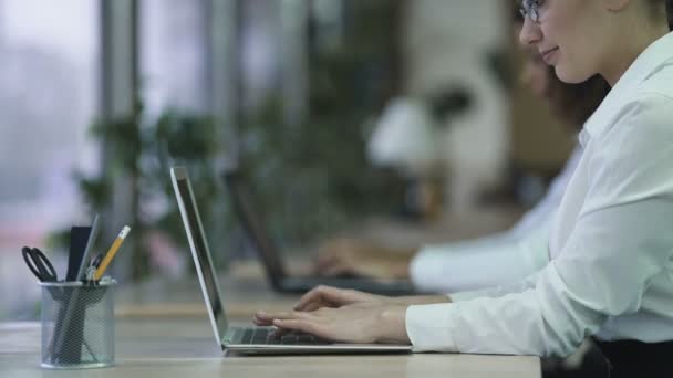 Donna di successo digitando e-mail sul computer portatile, donna sorridente che si gode il lavoro in ufficio — Video Stock