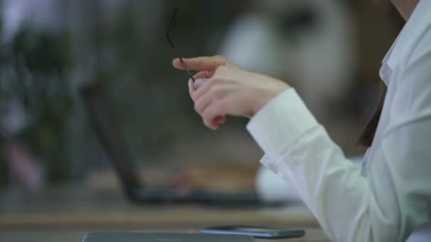 Mujer joven con mala vista poniéndose gafas, secretaria en el trabajo — Vídeos de Stock