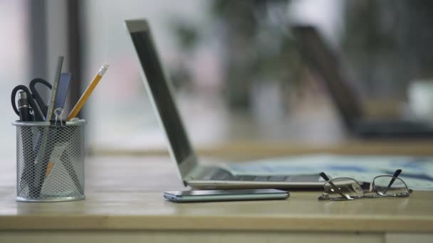 Γυναικείο χέρι λαμβάνοντας smartphone από desk με laptop, χώρο εργασίας στο γραφείο της εταιρείας — Αρχείο Βίντεο