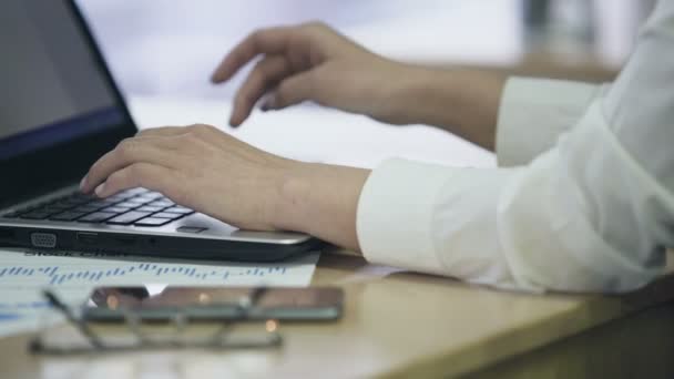 Manos femeninas escribiendo texto en el ordenador portátil, empleado de oficina ocupado trabajando en el proyecto — Vídeos de Stock