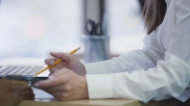 Not alma raporu tartışıyor ve smartphone üzerinde hesaplamalar yapmak iş arkadaşları