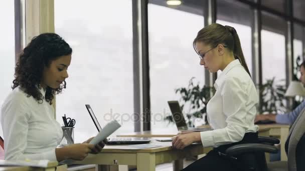 Zwei Kolleginnen beenden Diskussion und arbeiten getrennt an Projekt weiter — Stockvideo