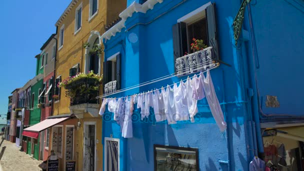 Lavandería blanca secado en la fachada de la casa azul, Burano calle isla, la vida en Italia — Vídeo de stock