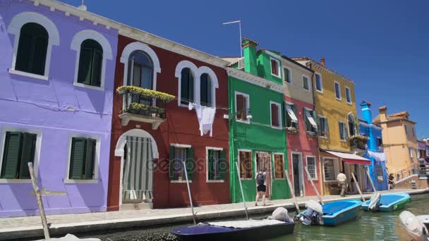 Viele entspannte Menschen flanieren in bunten Straßen auf der Insel Burano, Sommerpause — Stockvideo