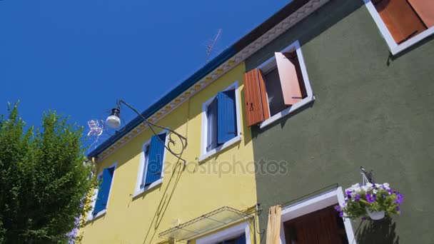 Maison d'habitation jaune vif voisine de bâtiments colorés bien entretenus — Video