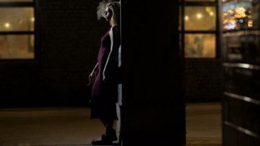 Güzel kadın gece kulübü girişine yakın, tek başına duran sigara dumanı parçasıyla birlikte kullanılmalıdır