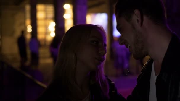 Влюблённая пара, стоящая рядом с ночным клубом и разговаривающая, первое свидание, отношения — стоковое видео
