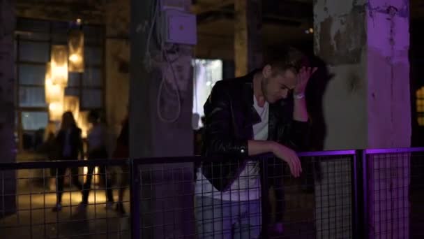 Młody zdenerwowany mężczyzna myśli o problemach stojąc w nocnym klubie hall — Wideo stockowe