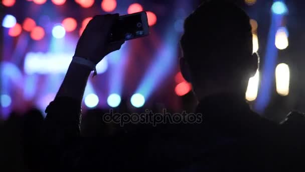 Happy man dancing and shooting video on smartphone at night club, concert — Stock Video