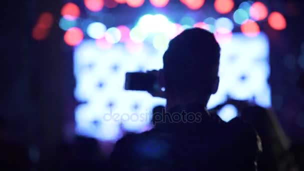 Active man shaking hand and filming live show at night club, dancing people — Stock Video