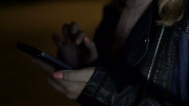 Sokakta tek başına duran ve haber smartphone cep telefonu ile kaydırma genç üzgün kadın