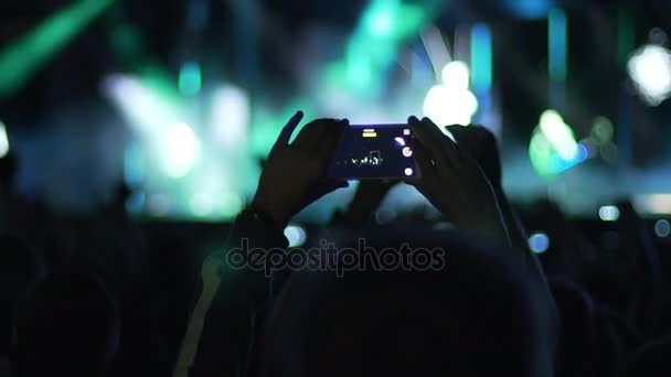 Tangan pria memegang smartphone di udara, film acara menakjubkan di atas panggung, slow-mo — Stok Video