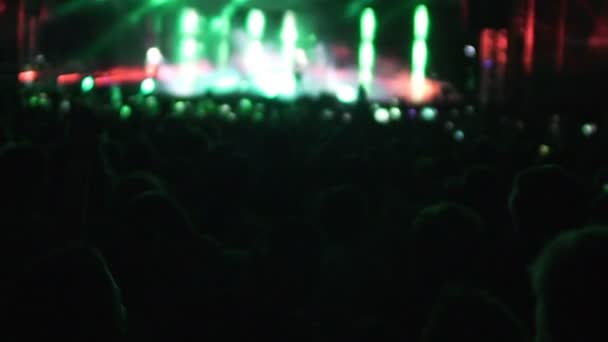 Silhouettes of people watching performance by singer, bright lights on stage — Stock Video