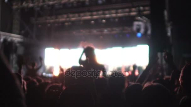 Sombras de muitos homens e mulheres desfrutando de rock star performance em concerto, slow-mo — Vídeo de Stock