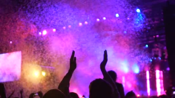 Lidské siluety tleská, sledovat úžasné barevné světlo a konfety show — Stock video