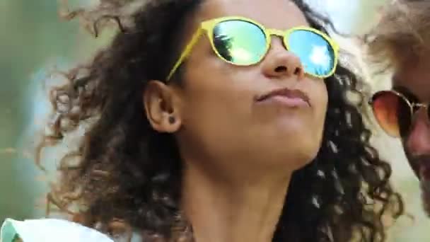 Ελκυστική κοπέλα biracial σε κίτρινα γυαλιά ηλίου, χορός, που τραγουδά μεταξύ φίλων — Αρχείο Βίντεο