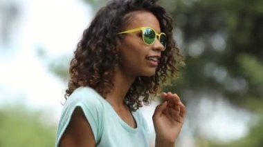 Dans ve onun güneş gözlüğü koyarak flört güzel biracial Bayan