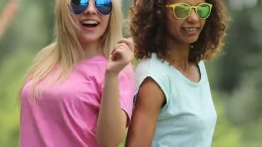 İki sevimli kız arka arkaya dokunuyor, onların parmak dayama kalça ile dans