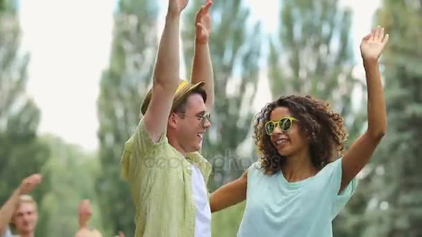 Jonge man en vrouw dansen op buiten muziek fest met hun hand omhoog in de lucht — Stockvideo