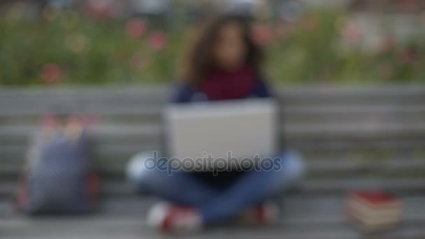 Giovane signora razza mista scrittura saggio sul computer portatile, studio, pieno di ispirazione — Video Stock